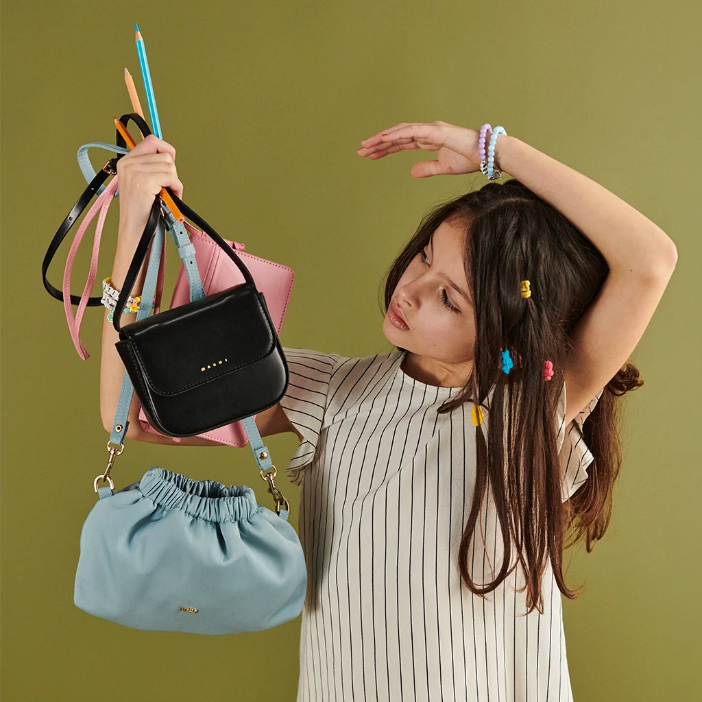A girl with a striped dress, holding three bags