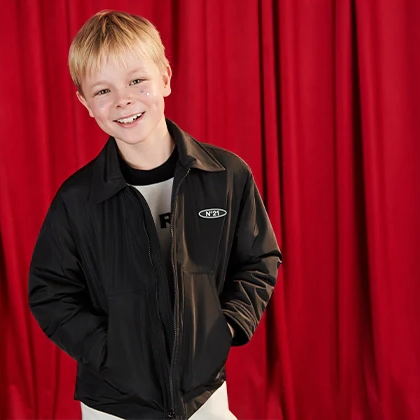 Jackets category - A boy smiling with a black jacket and a red background