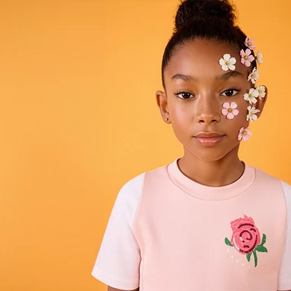 A girl wearing a stylish T-shirt with flowers on his face and a yellow background