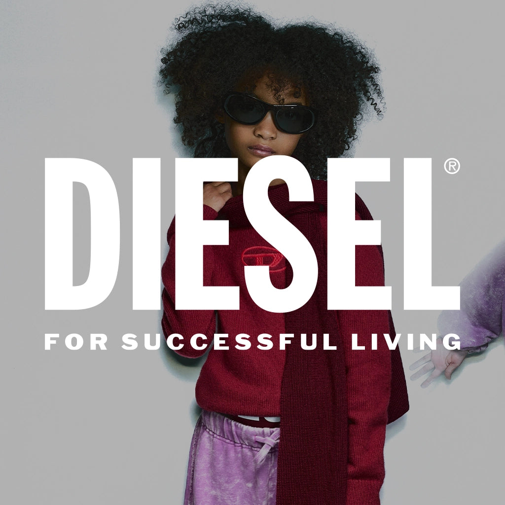A model with dark curly hair wearing a dark red knit sweater, purple tie-dye pants, and black sunglasses, set against a solid gray background with a large white 'DIESEL' logo and the text 'FOR SUCCESSFUL LIVING'.